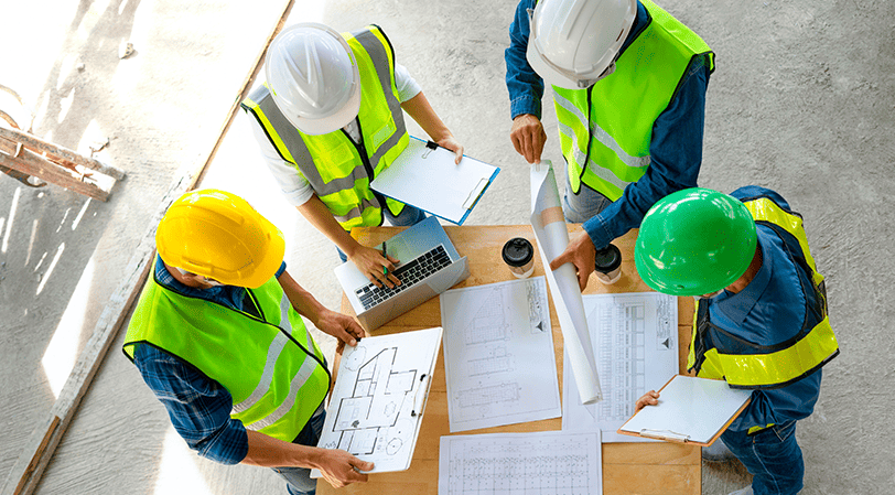 group of builders checking papers 